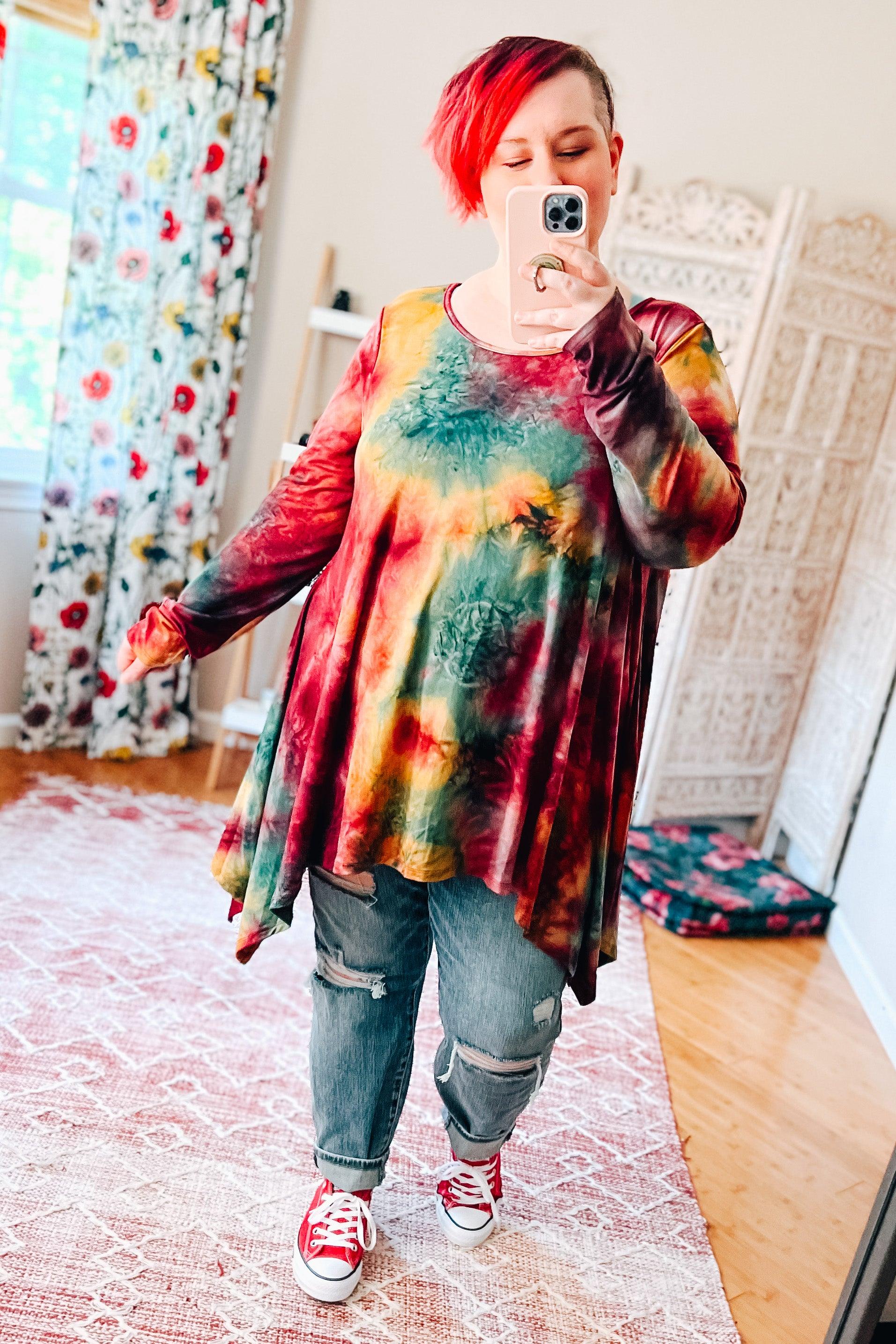 Long-sleeve oversized tunic in ruby with green and mustard tie-dye paired with ripped jeans and red sneakers