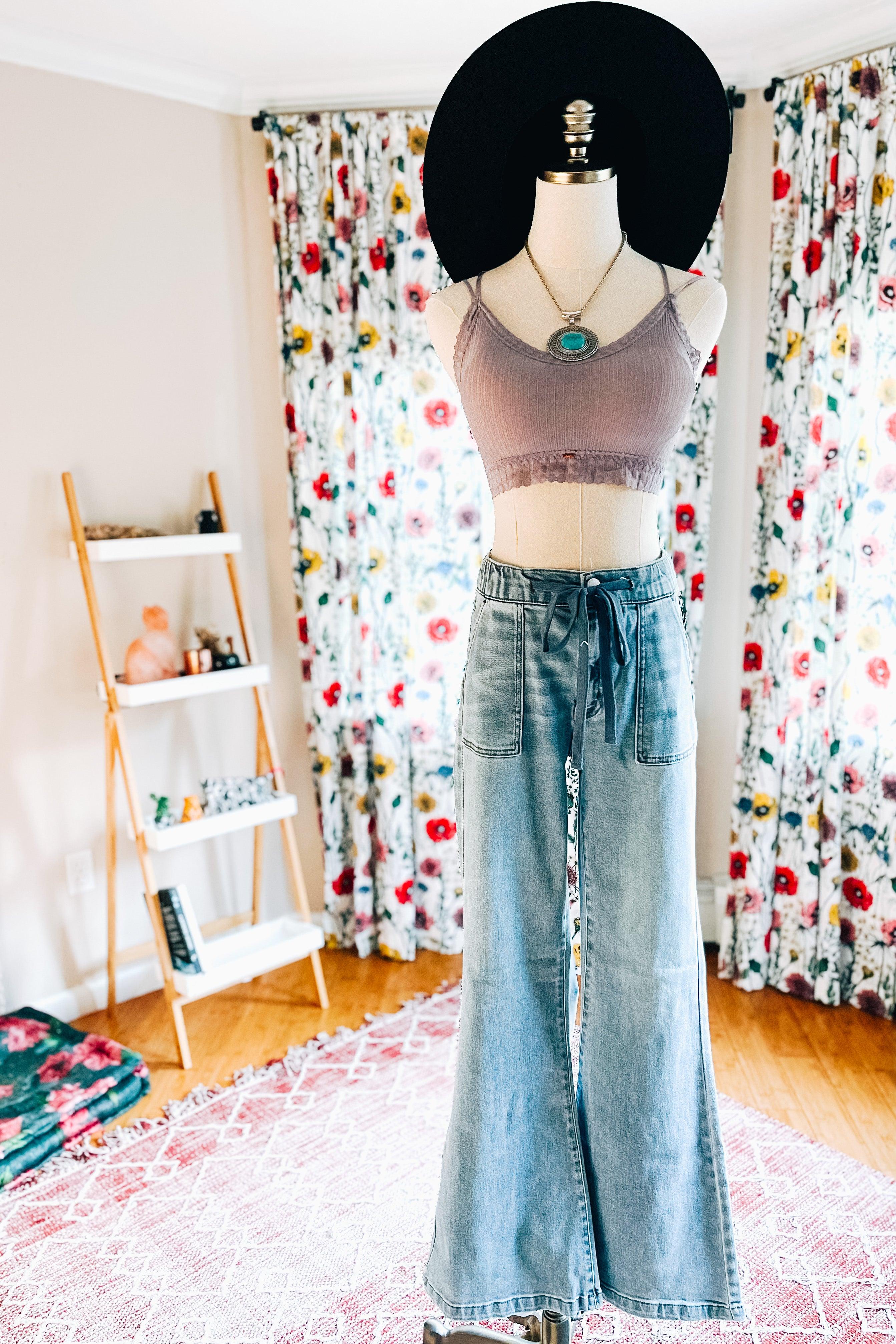 Lilac ribbed lace bralette paired with wide-leg denim jeans and accessorized with a turquoise pendant and black wide hat