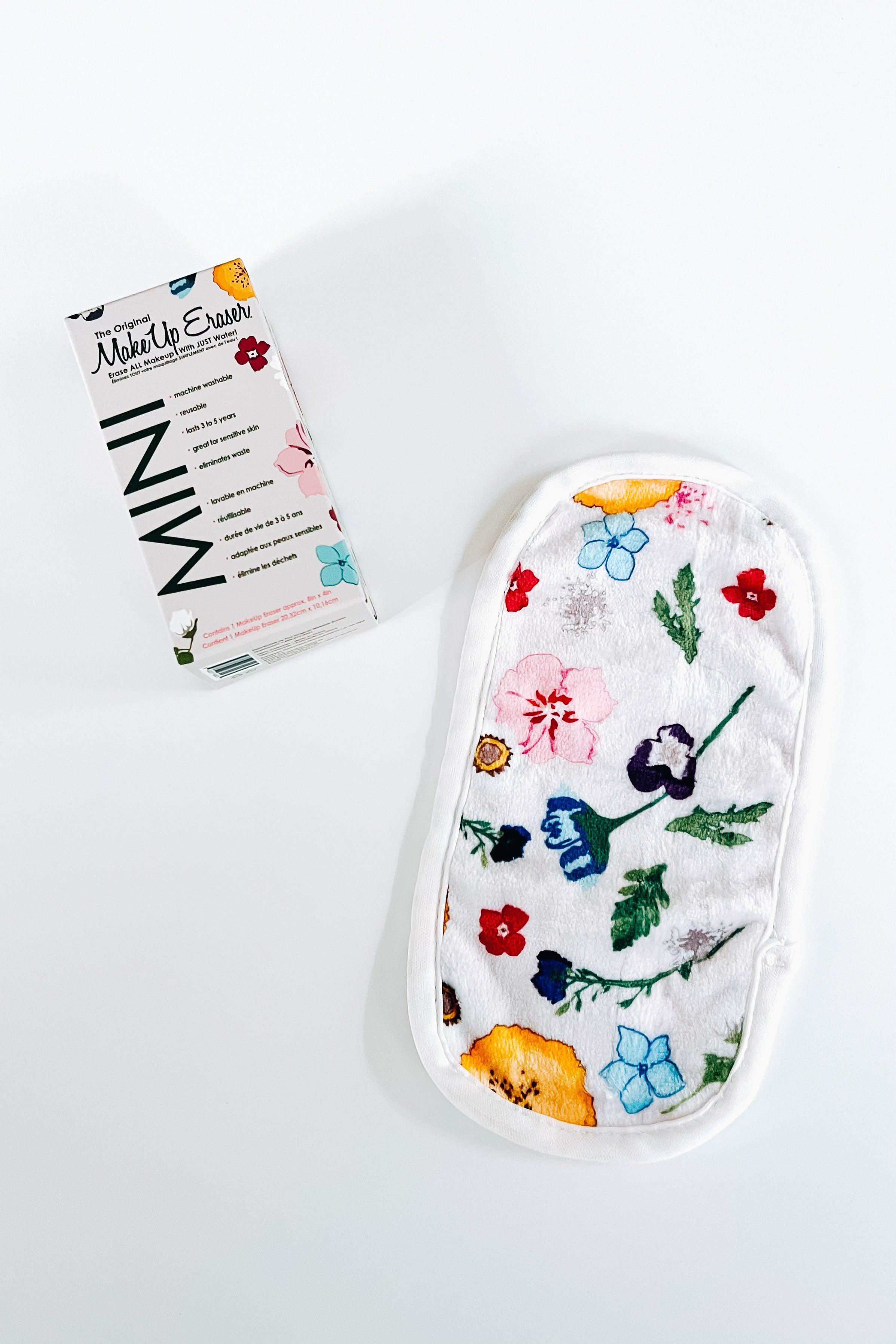 Multicolor mini makeup eraser with vibrant wildflower prints next to its packaging on white background