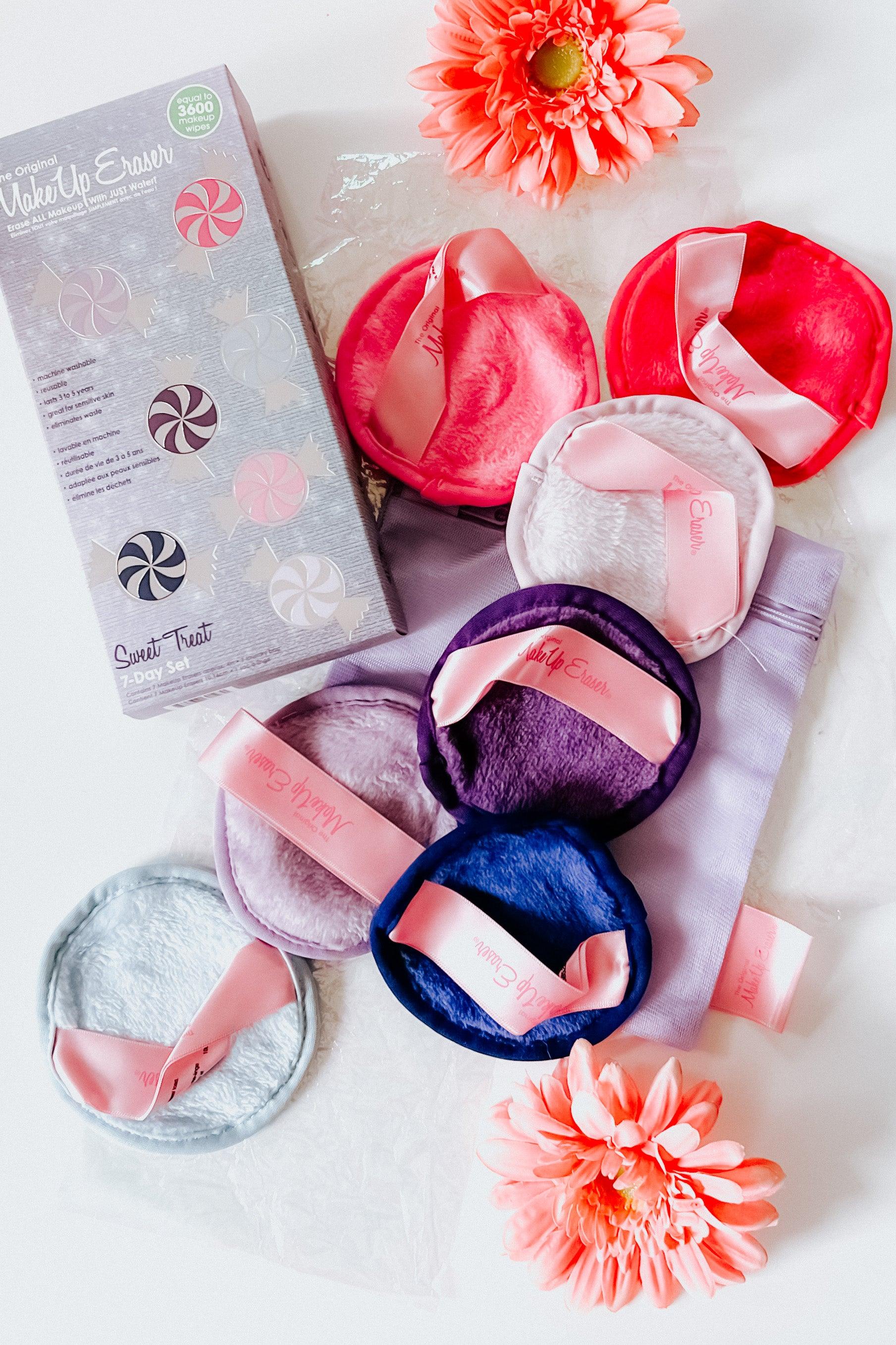 Plush reusable makeup remover pads in pink, purple, and blue shades arranged with branded packaging and flowers