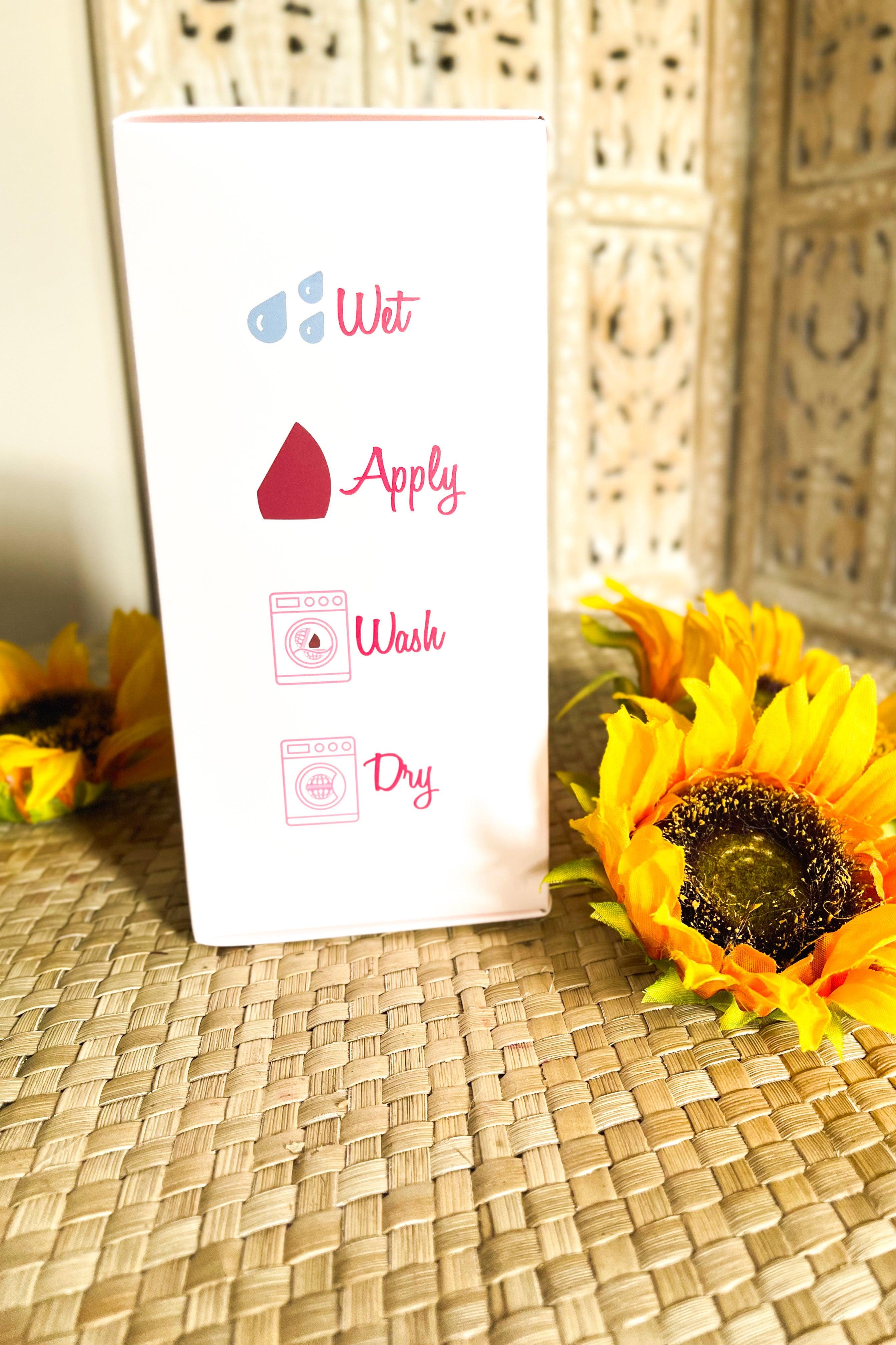 White product packaging with pink icons and instructions surrounded by bright yellow sunflowers on woven surface