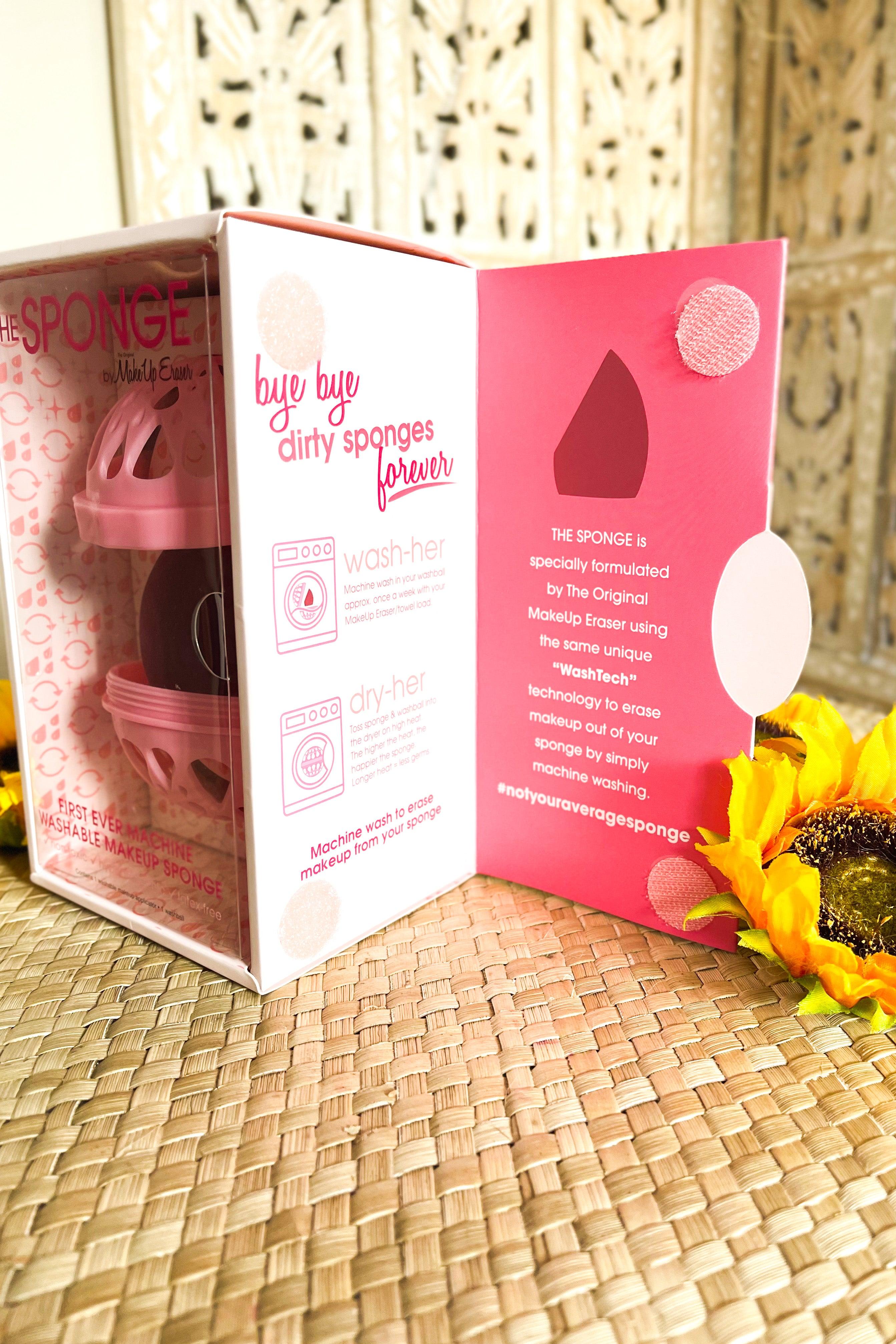 Pink makeup sponge set with clear packaging on woven mat next to bright yellow sunflower and informational inserts