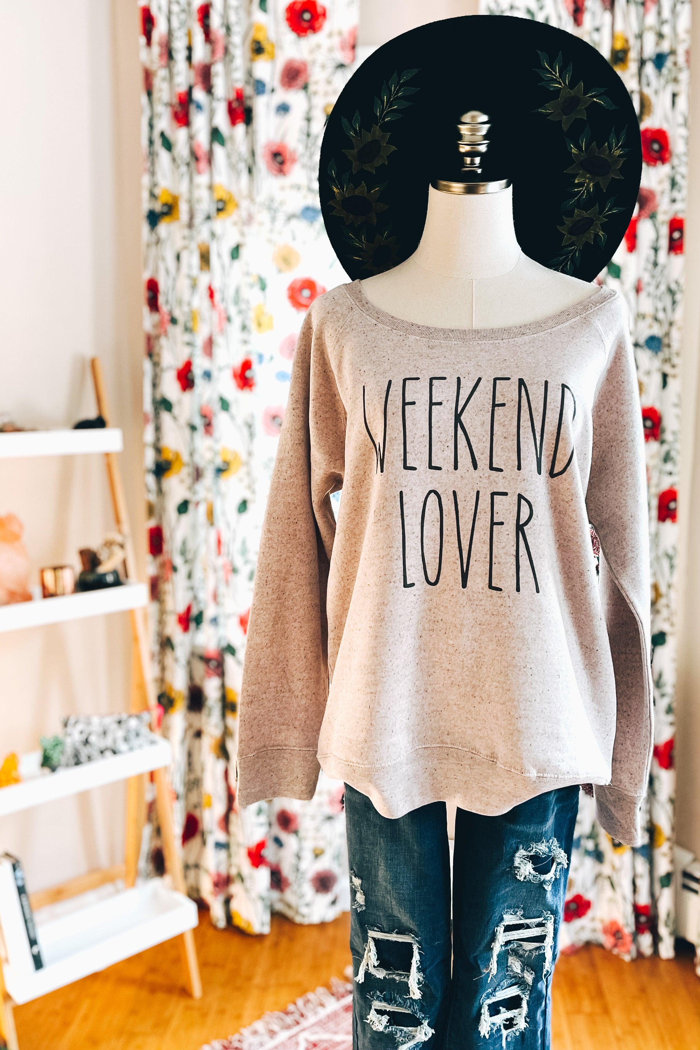 Mannequin wearing blush scoop neck pullover with "Weekend Lover" text paired with distressed blue jeans indoors