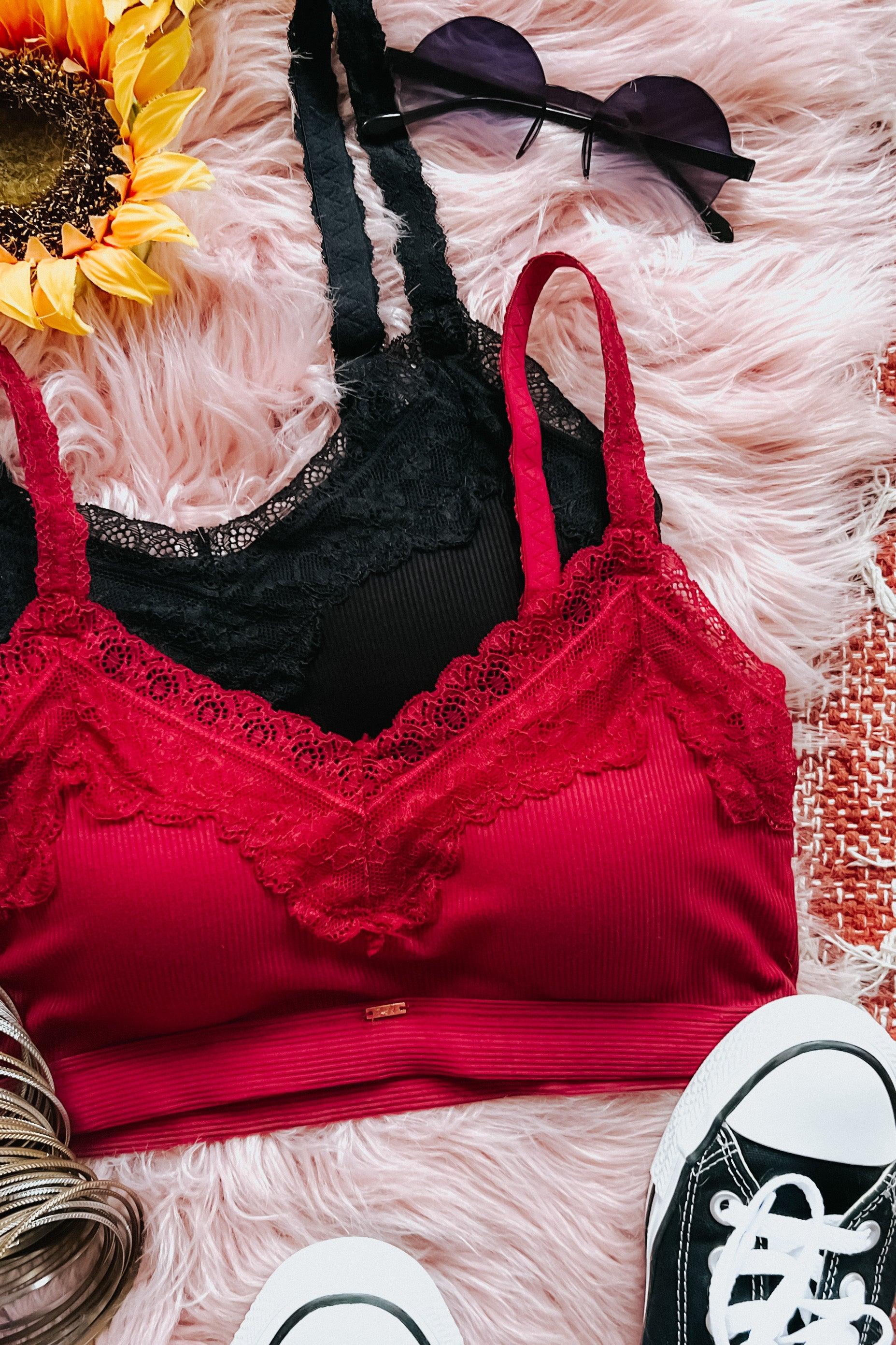 Wine-colored lace trim bralette with ribbed fabric layered over black bralette, styled with sunglasses and sneakers on soft pink fur