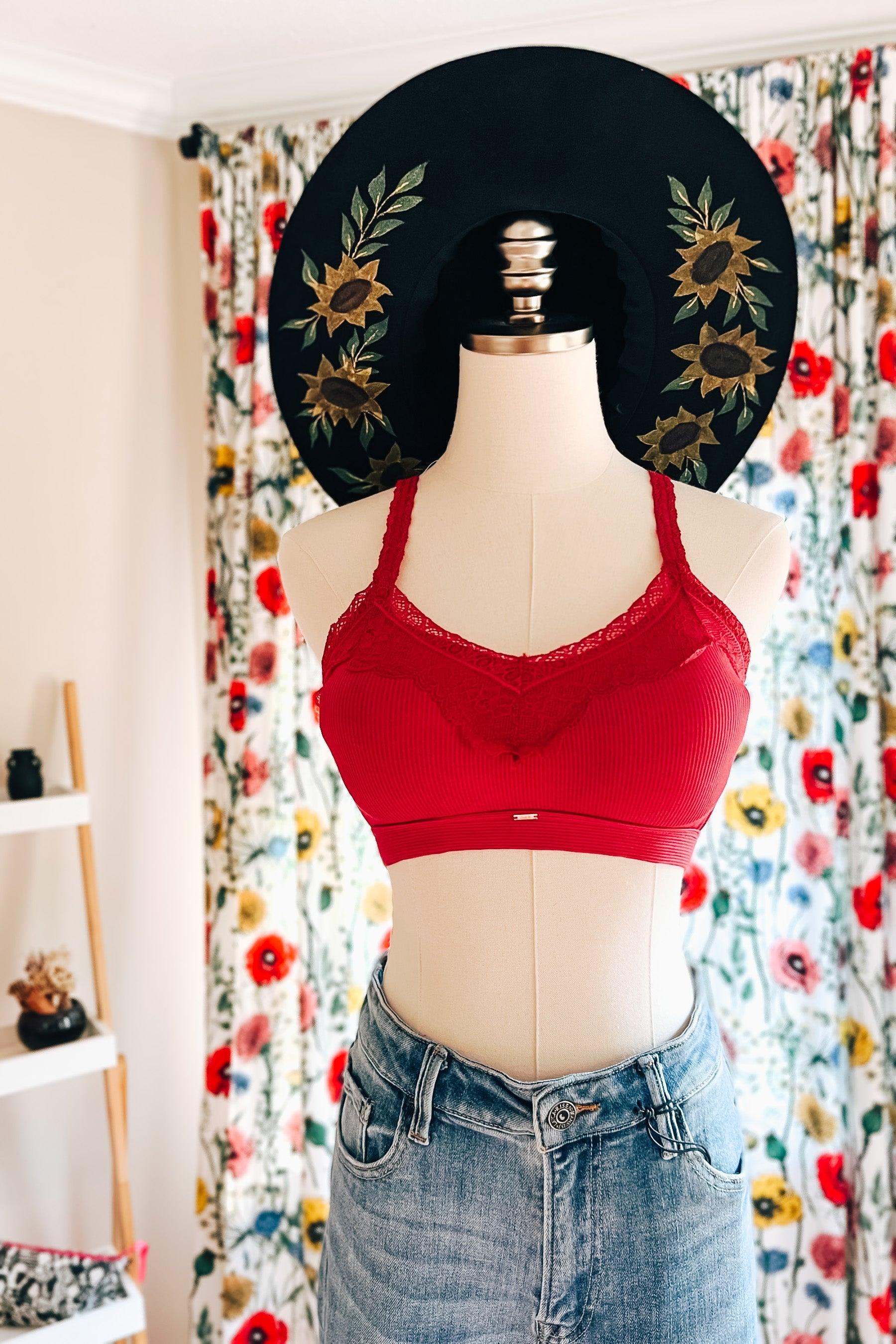 Wine-colored lace-trim bralette with ribbed fabric displayed on mannequin wearing high-waisted denim and floral embroidered black hat